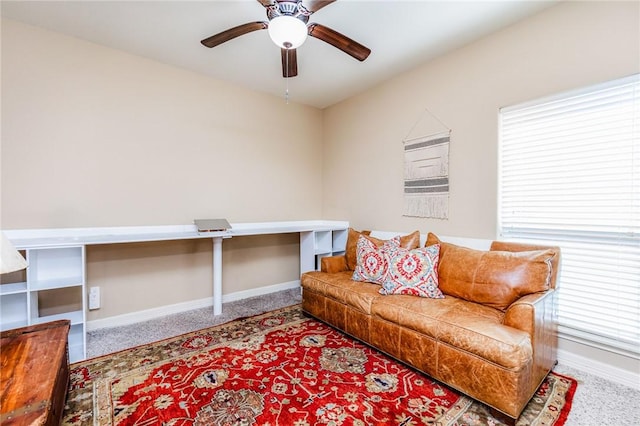 living area featuring carpet floors, a ceiling fan, and baseboards