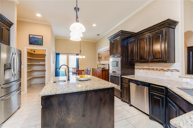 kitchen featuring crown molding, light tile patterned floors, stainless steel appliances, tasteful backsplash, and an island with sink