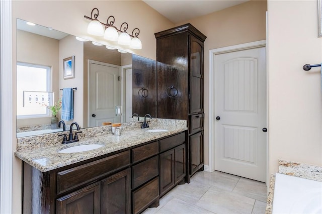 bathroom with double vanity, a sink, and tile patterned floors