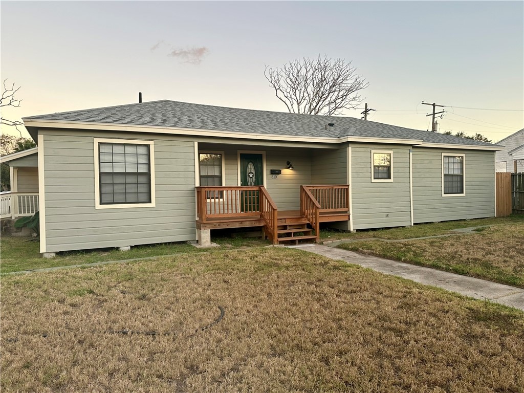 view of front of house featuring covered porch and a lawn