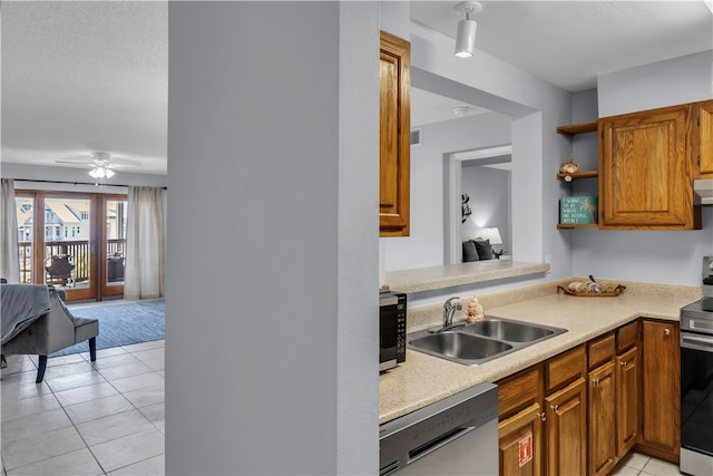 kitchen with sink, kitchen peninsula, appliances with stainless steel finishes, ceiling fan, and light tile patterned floors