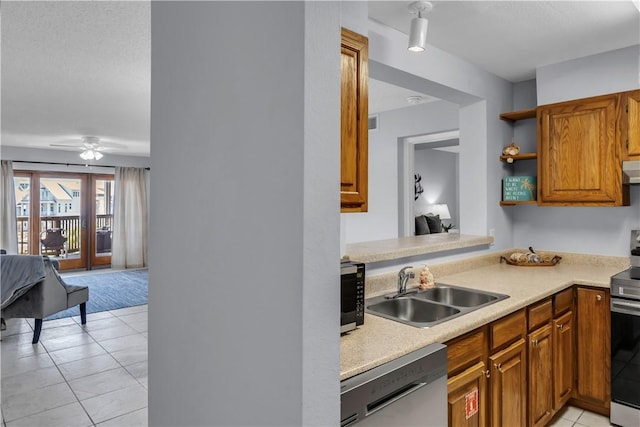 5973 State Highway 361 Unit 203, Port Aransas, TX 78373 - kitchen with stainless steel appliances, a sink, light countertops, brown cabinets, and light tile patterned floors