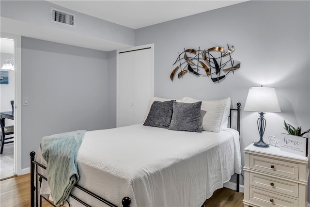 bedroom with light hardwood / wood-style floors and a closet