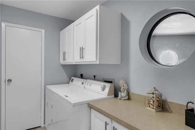 laundry room with washing machine and dryer and cabinets