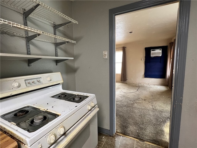 kitchen with a wall mounted air conditioner, electric range, and dark colored carpet