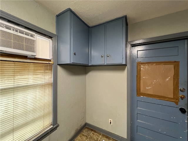 clothes washing area featuring a textured ceiling