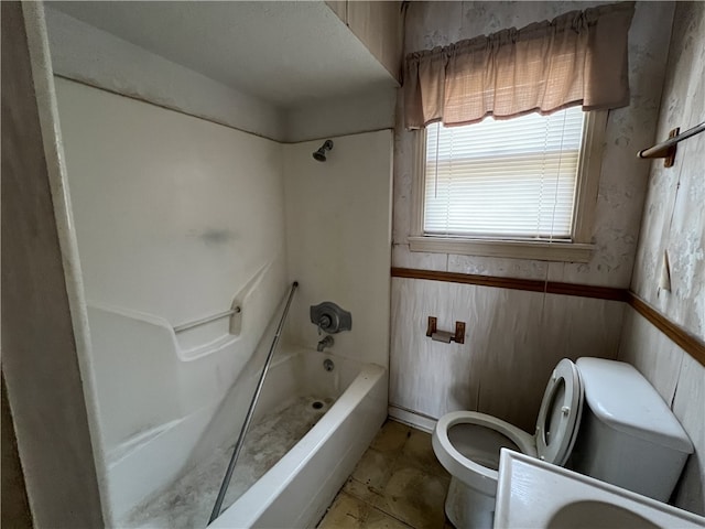 bathroom featuring bathtub / shower combination and toilet