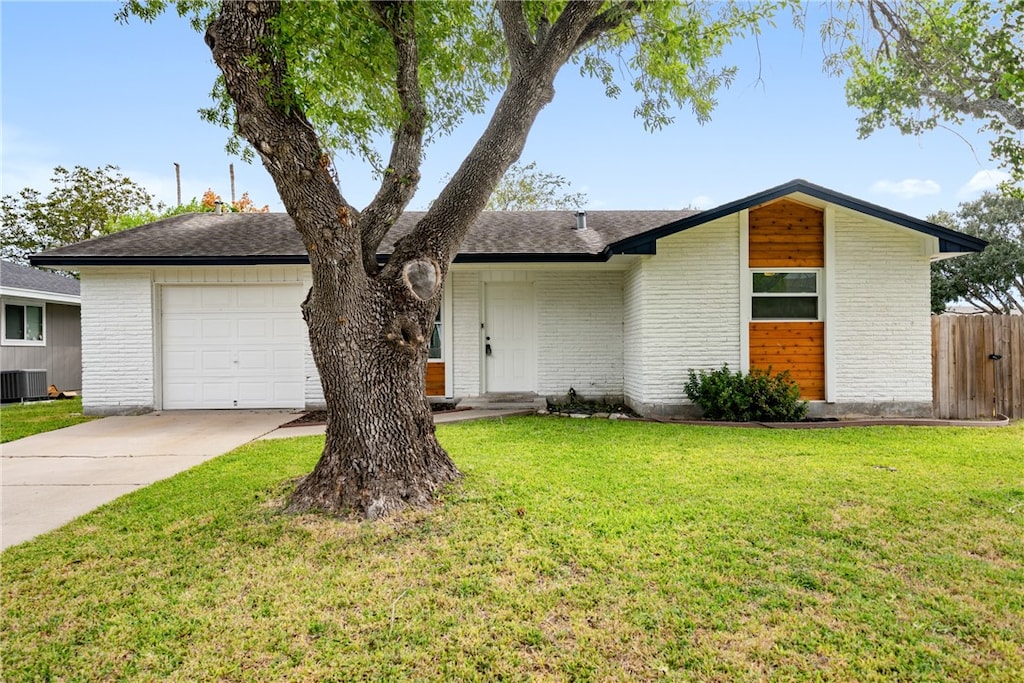 single story home featuring a garage, cooling unit, and a front yard