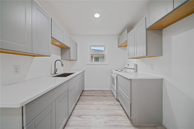 kitchen with light hardwood / wood-style floors, white range with electric cooktop, sink, and gray cabinetry