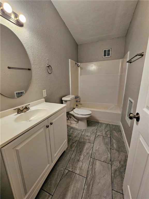 full bathroom with toilet, vanity, and shower / bath combination