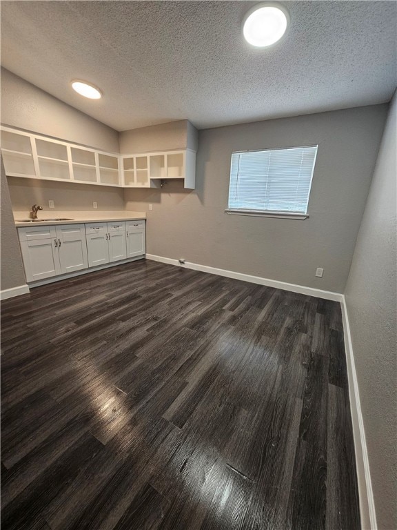 interior space featuring dark hardwood / wood-style floors, a textured ceiling, and sink