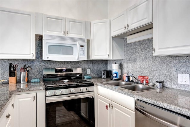 kitchen with appliances with stainless steel finishes, white cabinets, and a sink