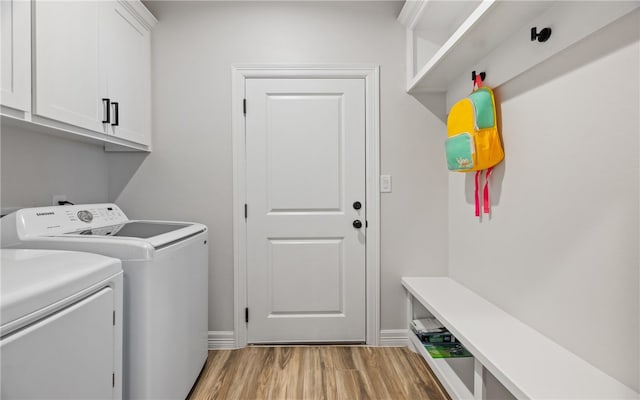 laundry room featuring cabinets, washer and clothes dryer, and light wood-type flooring