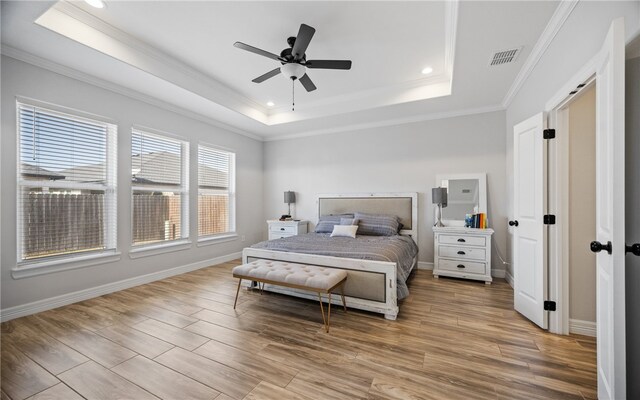 bedroom featuring ceiling fan, ornamental molding, a raised ceiling, and light hardwood / wood-style floors