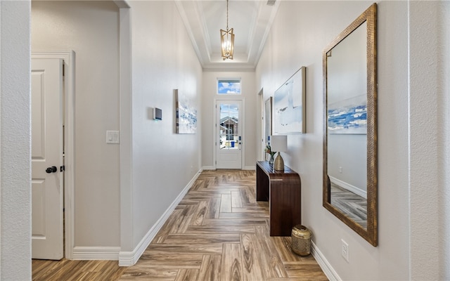 doorway featuring an inviting chandelier, parquet flooring, and ornamental molding