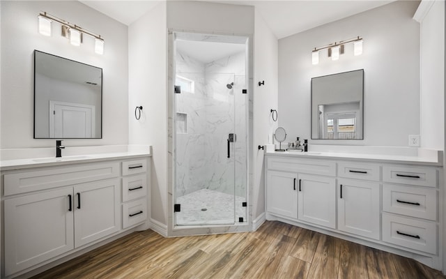 bathroom with wood-type flooring, an enclosed shower, and vanity