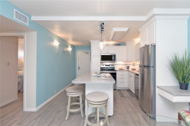 14810 Windward Dr Unit 203, Corpus Christi, TX 78418 - kitchen with stainless steel appliances, light wood-style floors, white cabinetry, and backsplash