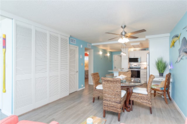 14810 Windward Dr Unit 203, Corpus Christi, TX 78418 - dining space featuring light wood finished floors, ceiling fan, and a textured ceiling