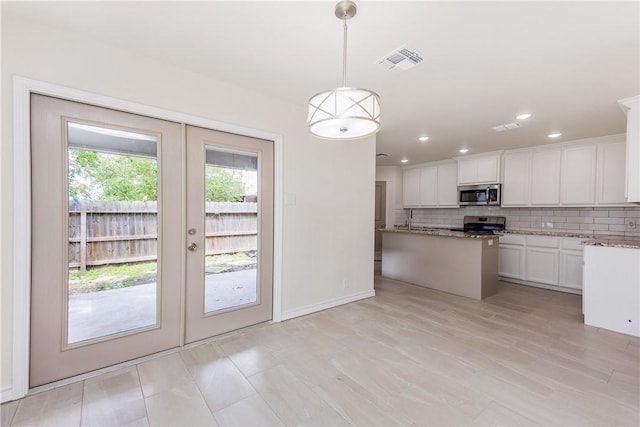 2325 Roseland Dr, Corpus Christi, TX 78414 - kitchen with light stone counters, stainless steel appliances, white cabinets, visible vents, and french doors