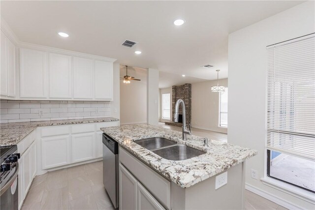 2325 Roseland Dr, Corpus Christi, TX 78414 - kitchen featuring an island with sink, decorative backsplash, appliances with stainless steel finishes, a sink, and visible vents