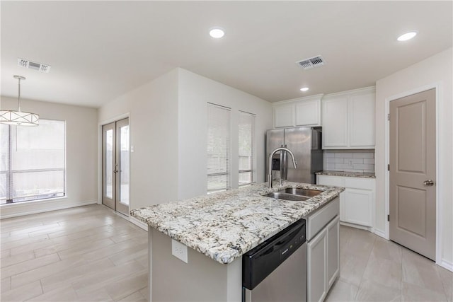 2325 Roseland Dr, Corpus Christi, TX 78414 - kitchen featuring visible vents, stainless steel appliances, light stone countertops, and a sink