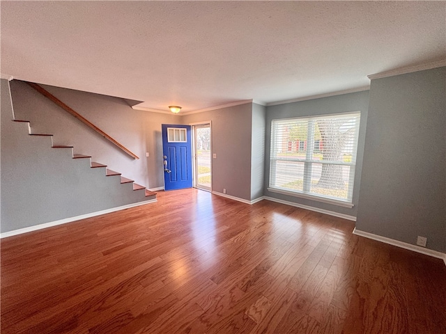 unfurnished living room featuring ornamental molding, a textured ceiling, and hardwood / wood-style flooring