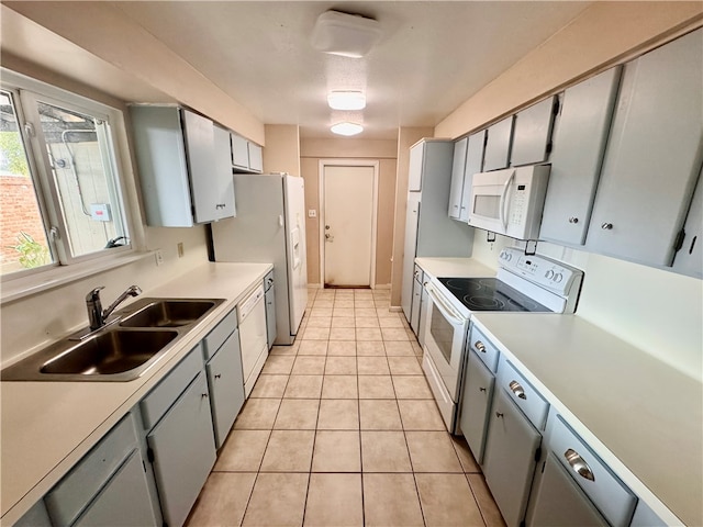 kitchen with gray cabinetry, white appliances, sink, and light tile patterned floors