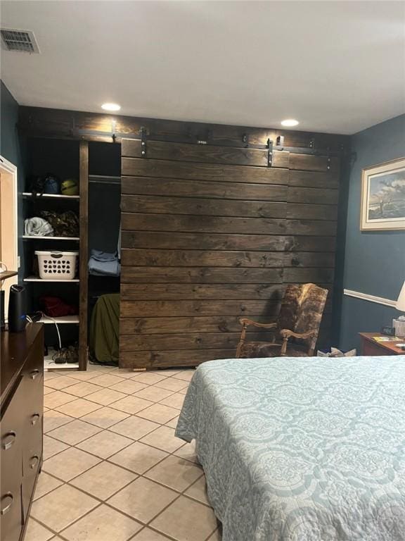 66 Redfish Dr, Rockport, TX 78382 - bedroom with a barn door, light tile patterned flooring, and recessed lighting