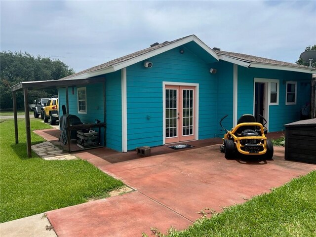 66 Redfish Dr, Rockport, TX 78382 - back of property featuring french doors, a lawn, and a patio