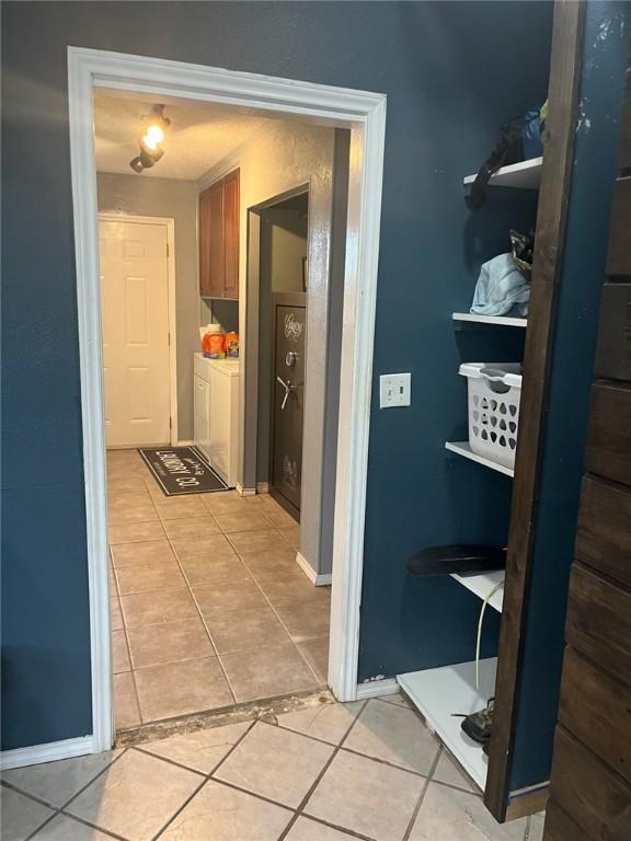66 Redfish Dr, Rockport, TX 78382 - hallway with washing machine and clothes dryer and light tile patterned flooring