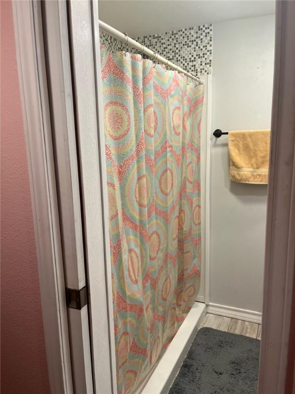 66 Redfish Dr, Rockport, TX 78382 - full bathroom with wood finished floors and a shower with shower curtain