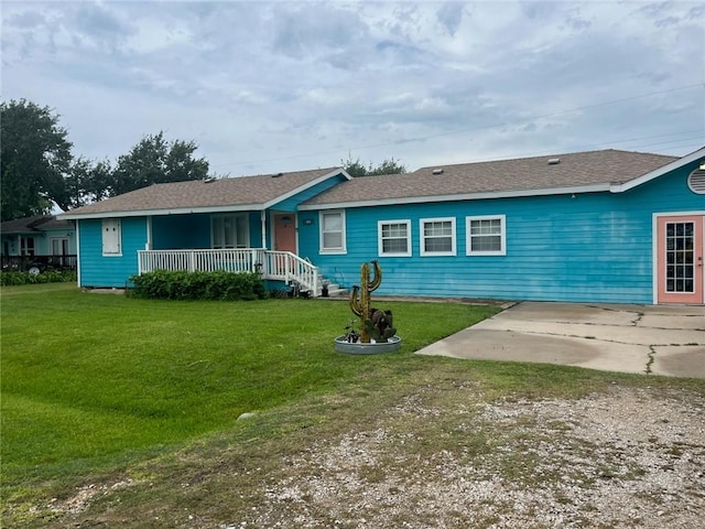 66 Redfish Dr, Rockport, TX 78382 - single story home with a front yard, covered porch, a shingled roof, and a patio area