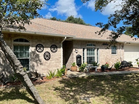 ranch-style home featuring a front lawn and a garage