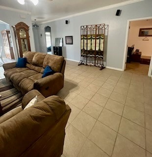 living room with ceiling fan, crown molding, and light tile patterned floors