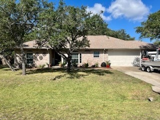 single story home featuring a garage and a front yard