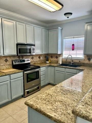 861 Redwood Ave, Rockport, TX 78382 - kitchen with stainless steel appliances, a sink, decorative backsplash, gray cabinetry, and crown molding
