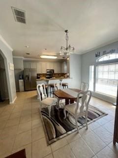 861 Redwood Ave, Rockport, TX 78382 - dining room with light tile patterned flooring, a chandelier, and crown molding