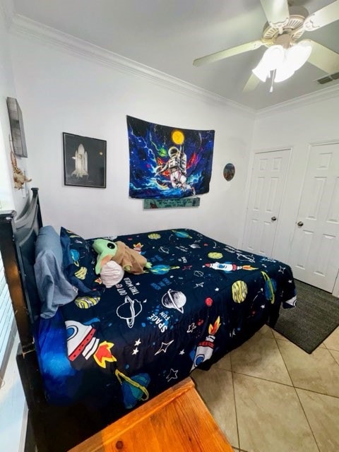 tiled bedroom featuring ceiling fan and ornamental molding