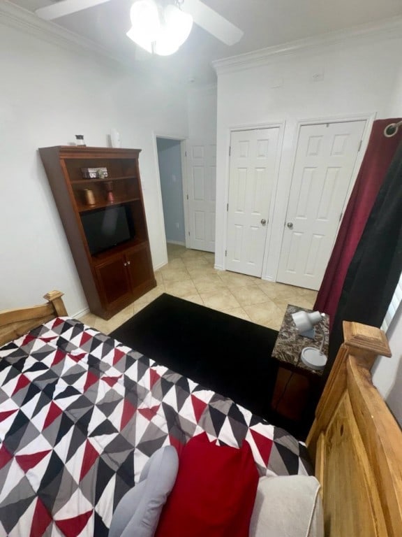 tiled bedroom featuring ornamental molding and ceiling fan