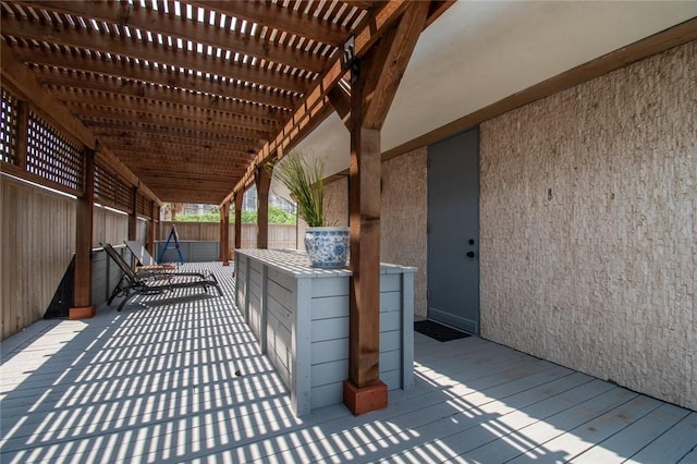 view of patio featuring fence, a pergola, and a wooden deck