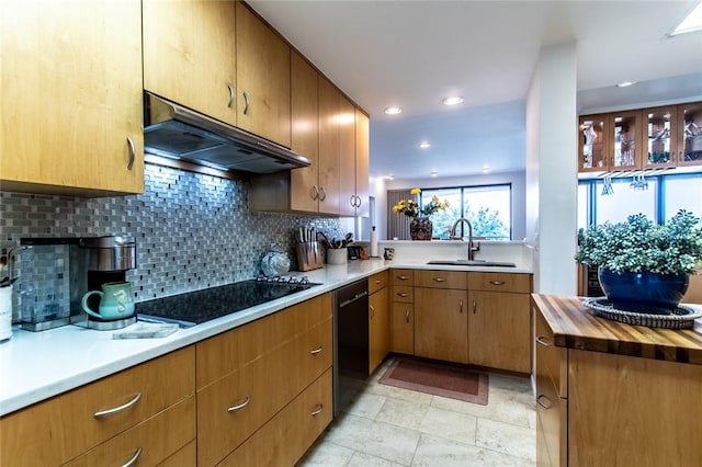 kitchen with tasteful backsplash, a sink, butcher block countertops, under cabinet range hood, and black appliances