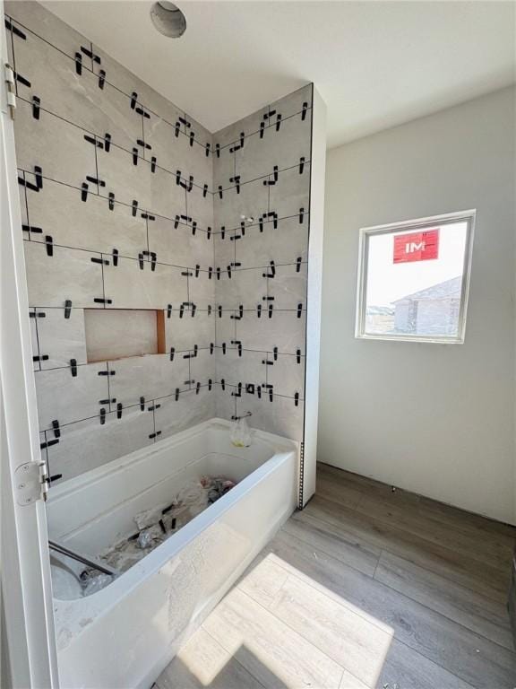 bathroom with bathing tub / shower combination and hardwood / wood-style floors