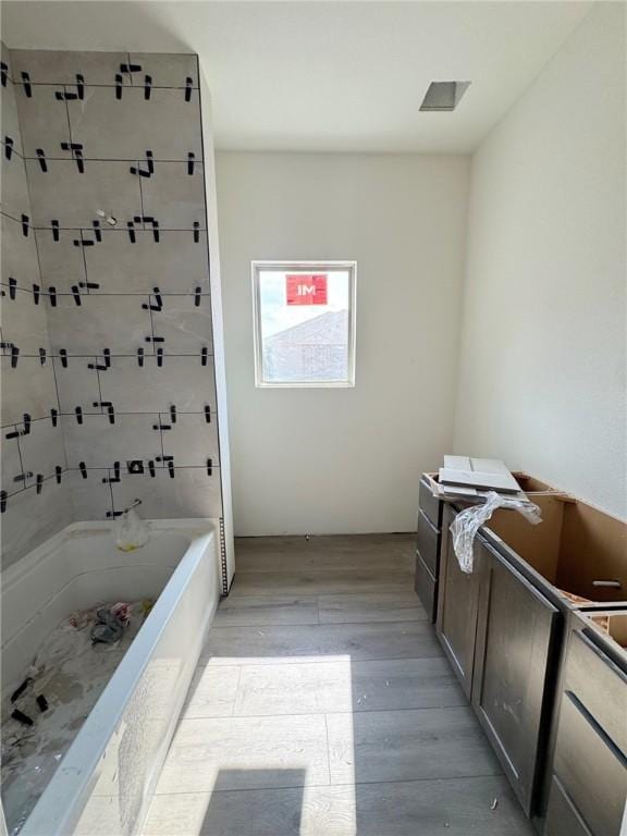 bathroom featuring hardwood / wood-style flooring and a bath