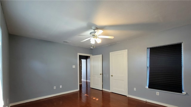 unfurnished bedroom featuring dark hardwood / wood-style flooring and ceiling fan