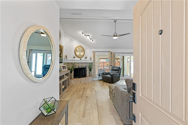 15209 Dasmarinas Dr, Corpus Christi, TX 78418 - living area with vaulted ceiling, light wood-style floors, ceiling fan, a brick fireplace, and plenty of natural light