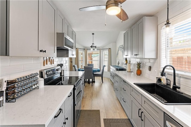 15209 Dasmarinas Dr, Corpus Christi, TX 78418 - kitchen with stainless steel appliances, decorative backsplash, hanging light fixtures, ceiling fan, and vaulted ceiling