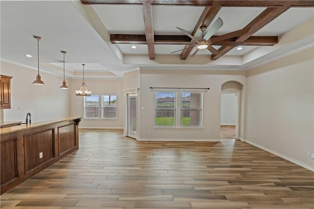 6913 Mets Ct, Corpus Christi, TX 78414 - unfurnished living room with ceiling fan, light wood finished floors, a chandelier, baseboards, and arched walkways