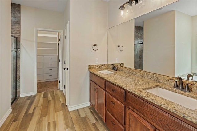 6913 Mets Ct, Corpus Christi, TX 78414 - full bathroom with a stall shower, wood finished floors, a spacious closet, double vanity, and baseboards