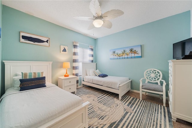 bedroom with a textured ceiling, carpet, a ceiling fan, and baseboards