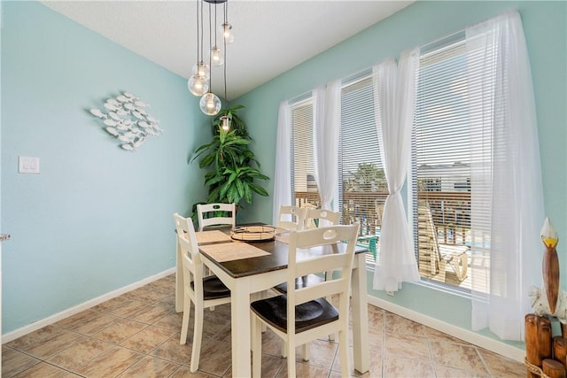 dining area with a healthy amount of sunlight, baseboards, and light tile patterned floors